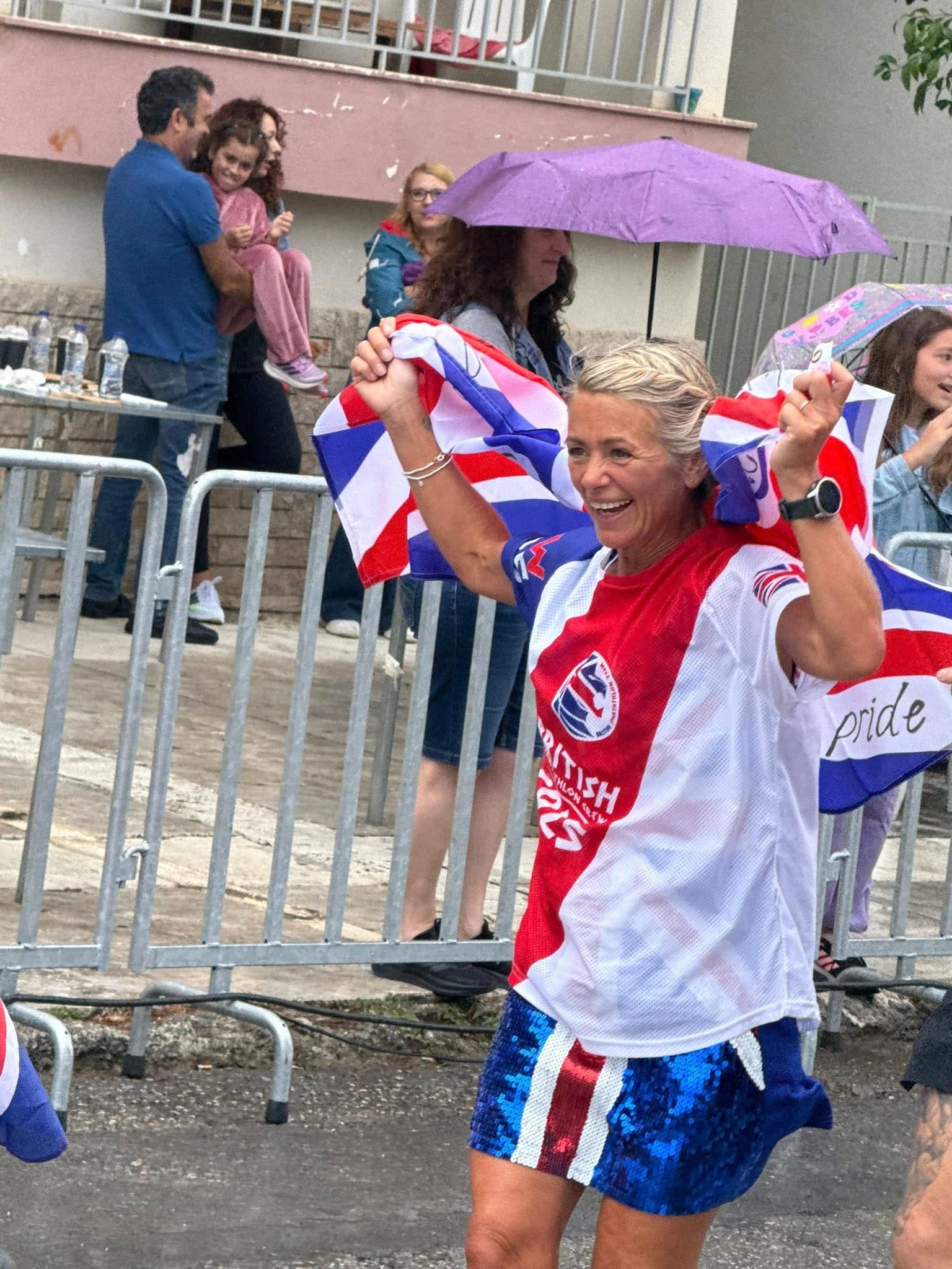 Chelle White celebrating at Spartathlon 2025, wrapped in a Union Jack in her GB team kit